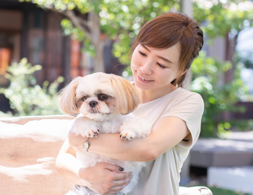 女性が犬を抱いている写真